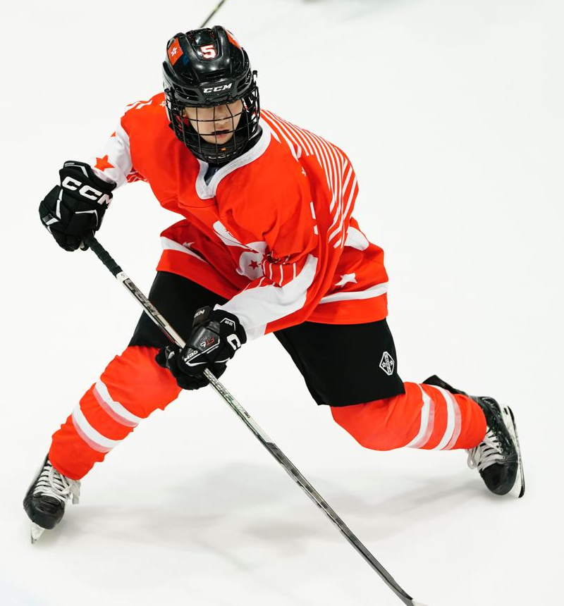 Agnes Chim skating with the puck in a Hong Kong jersey