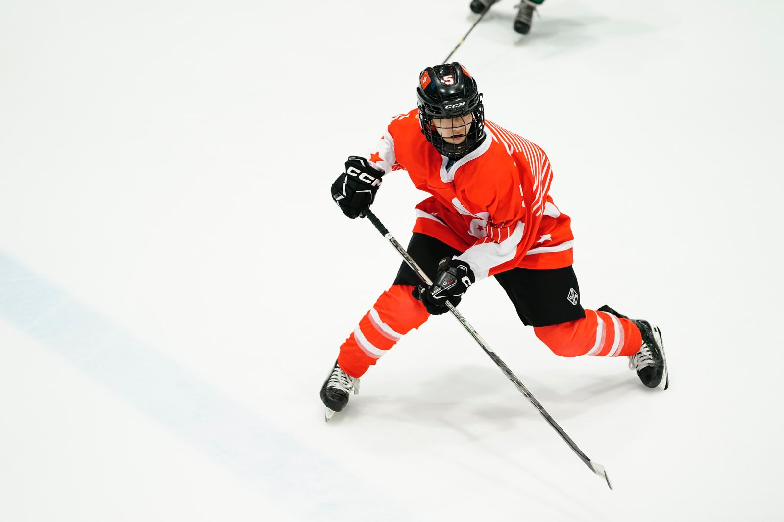 Agnes Chim driving up the ice in a Hong Kong national jersey